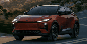 red 2026 Toyota c-hr all electric driving down highway